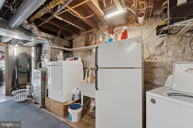unfinished basement with freestanding refrigerator and independent washer and dryer