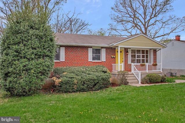 ranch-style home with a front yard, brick siding, a shingled roof, and covered porch