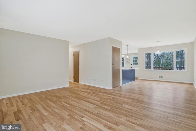unfurnished living room with visible vents, baseboards, and light wood finished floors