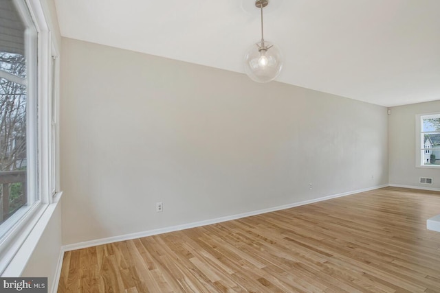 unfurnished room with visible vents, baseboards, and light wood-style floors