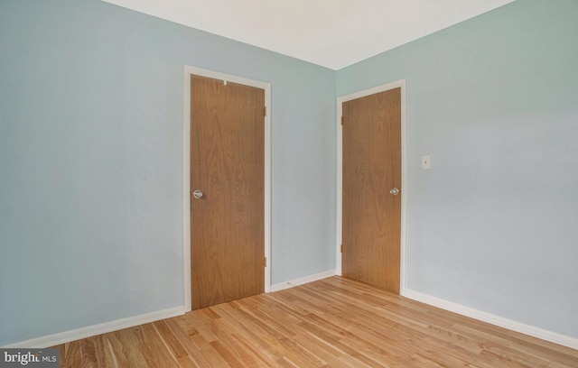 empty room with light wood-style flooring and baseboards