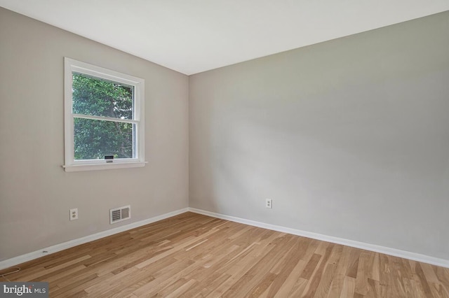 unfurnished room featuring visible vents, light wood-type flooring, and baseboards