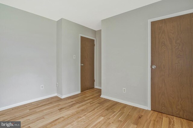 unfurnished room featuring light wood-style flooring and baseboards
