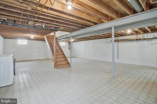 below grade area with washer / dryer, tile patterned floors, and stairway