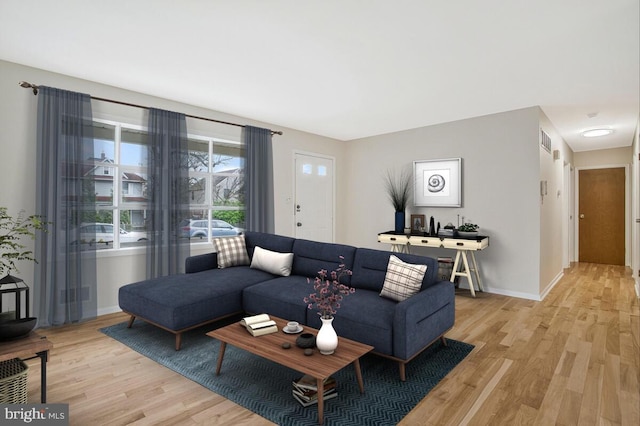 living area with visible vents, baseboards, and light wood-type flooring