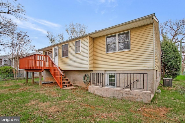 back of property with cooling unit, a lawn, a deck, and stairway