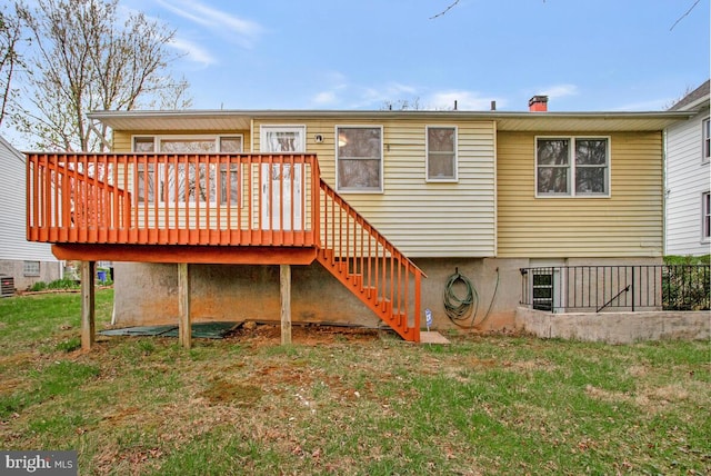 rear view of property featuring stairway, a deck, a chimney, and a lawn