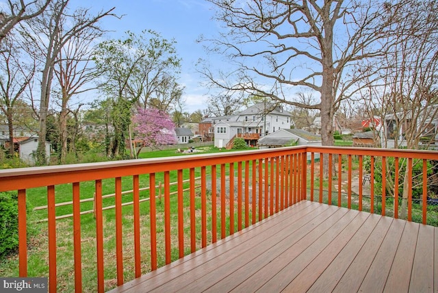 wooden terrace with a residential view and a lawn