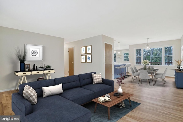 living area featuring light wood-style floors and baseboards