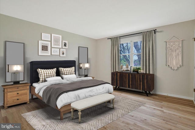 bedroom with light wood-style floors and baseboards