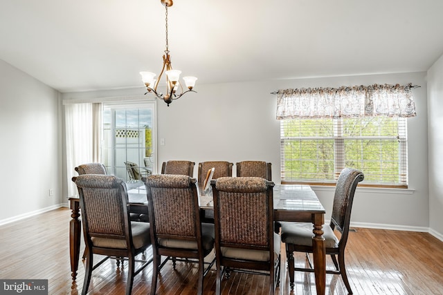 dining room with baseboards, a notable chandelier, and wood finished floors