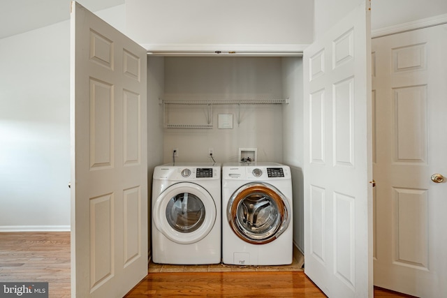 washroom with independent washer and dryer, laundry area, and wood finished floors
