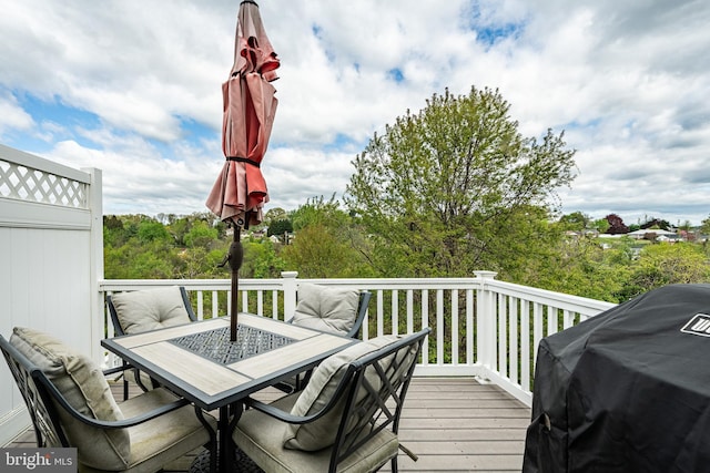 wooden deck featuring outdoor dining space and a grill