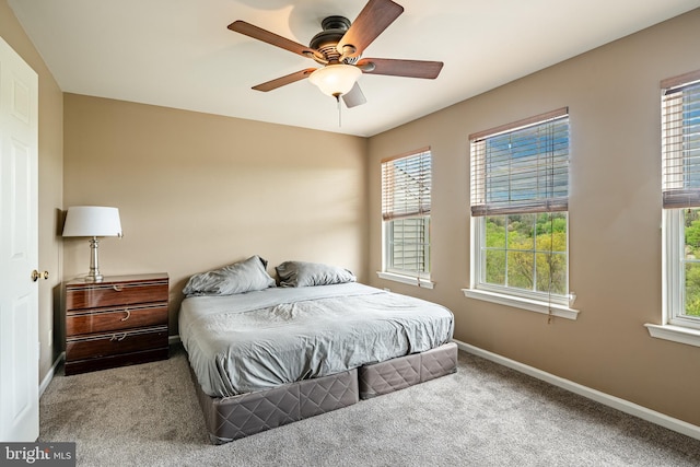 carpeted bedroom featuring baseboards and ceiling fan
