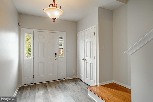 foyer featuring baseboards and wood finished floors