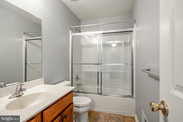 bathroom with toilet, tile patterned floors, shower / bath combination with glass door, and vanity