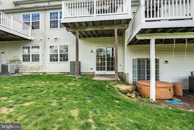 rear view of house with a yard and central air condition unit