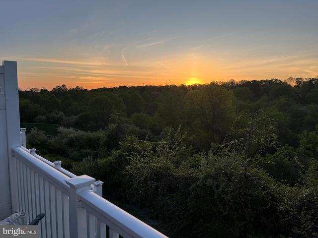 balcony featuring a wooded view