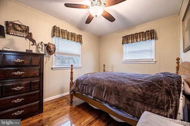 bedroom with ceiling fan, wood-type flooring, and baseboards