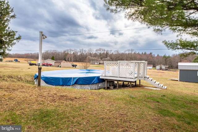 view of yard with an outbuilding, a storage shed, and a covered pool