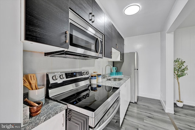 1629 Malvern St, Baltimore, MD 21224 - kitchen featuring light stone counters, a sink, light wood-style flooring, stainless steel appliances, and baseboards