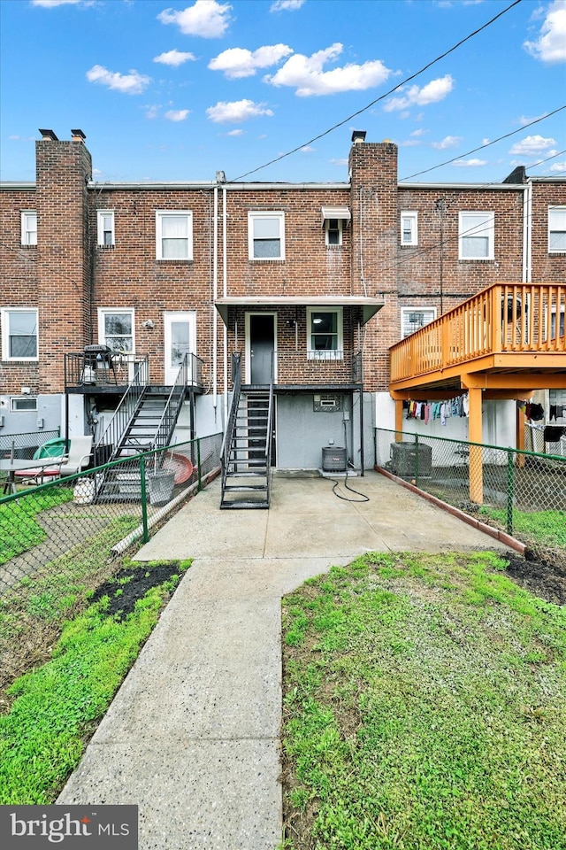 1629 Malvern St, Baltimore, MD 21224 - rear view of property featuring stairway, central air condition unit, fence, brick siding, and a patio