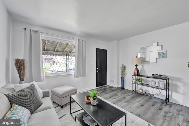 1629 Malvern St, Baltimore, MD 21224 - living room featuring wood finished floors, baseboards, and visible vents
