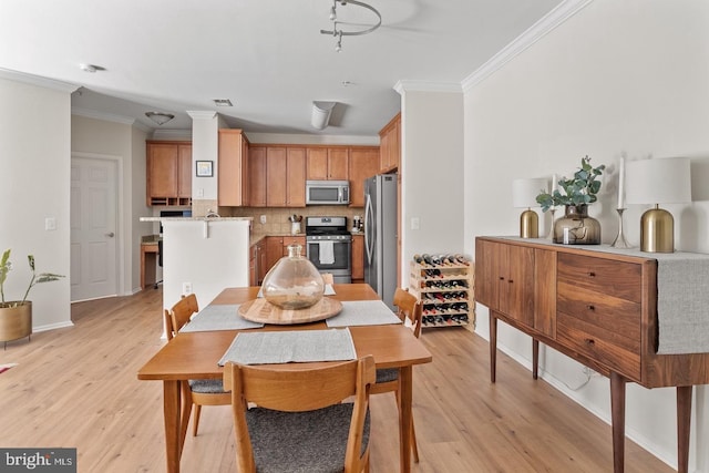 dining space with crown molding, light wood finished floors, and baseboards
