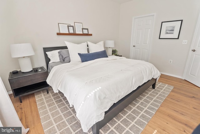bedroom featuring light wood-style flooring and baseboards