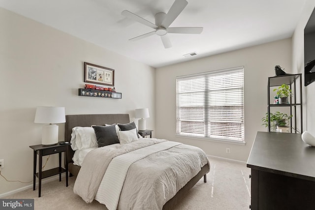 bedroom featuring light colored carpet, baseboards, and a ceiling fan