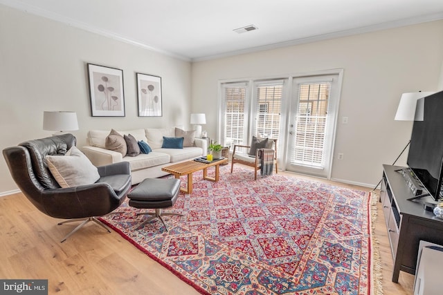 living area with light wood finished floors, crown molding, and baseboards