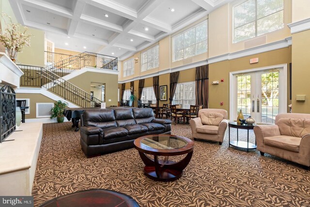 building lobby with a high ceiling, coffered ceiling, beam ceiling, stairs, and recessed lighting