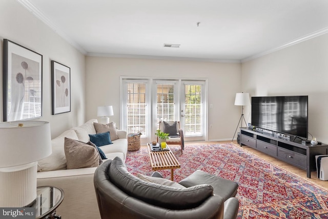 living area featuring crown molding, wood finished floors, and baseboards