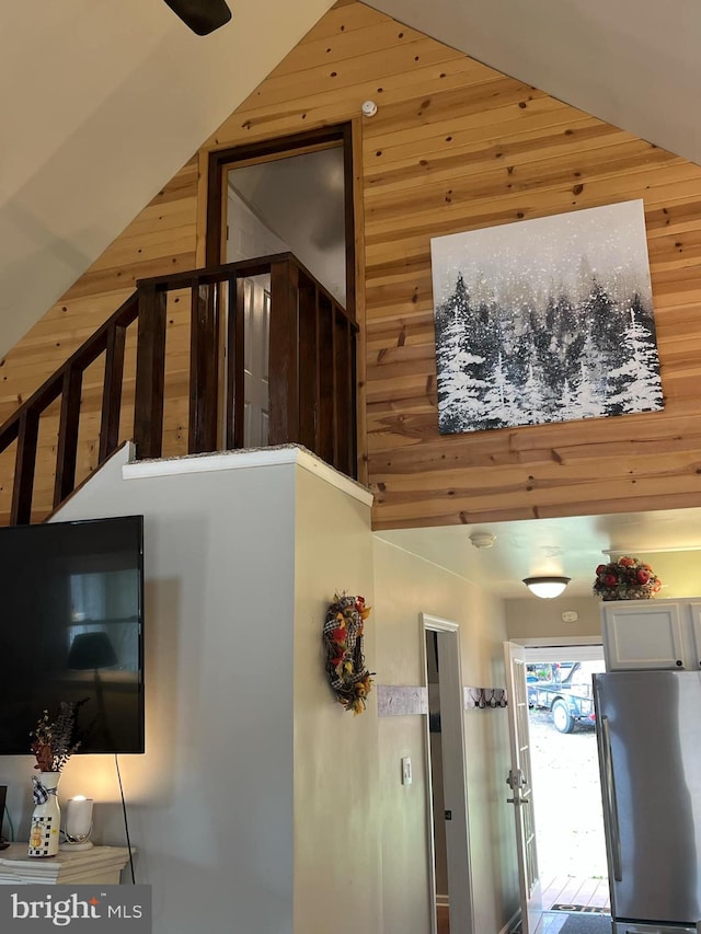 stairway with high vaulted ceiling and wood walls
