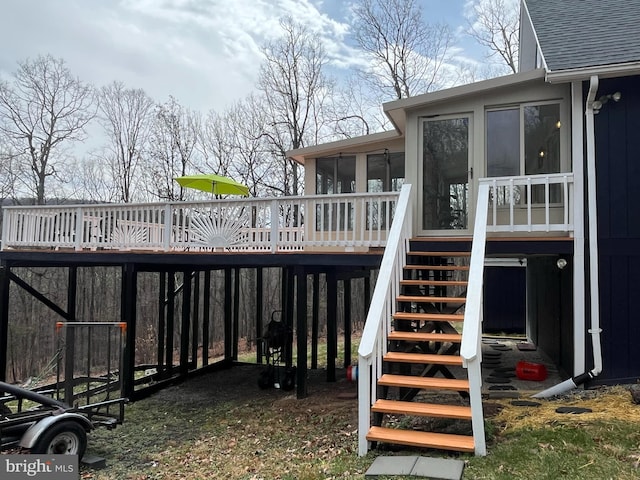 wooden terrace featuring a sunroom and stairway