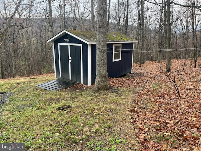 view of shed with a view of trees