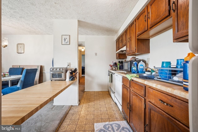 997 Heather Ridge Dr Unit 3G, Frederick, MD 21702 - kitchen featuring brown cabinetry, light floors, under cabinet range hood, a textured ceiling, and stove