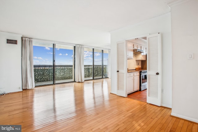400 Madison St Unit 1704, Alexandria, VA 22314 - unfurnished living room with light wood-type flooring, visible vents, baseboards, ornamental molding, and floor to ceiling windows