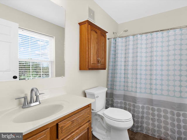 full bath with visible vents, curtained shower, vanity, and toilet