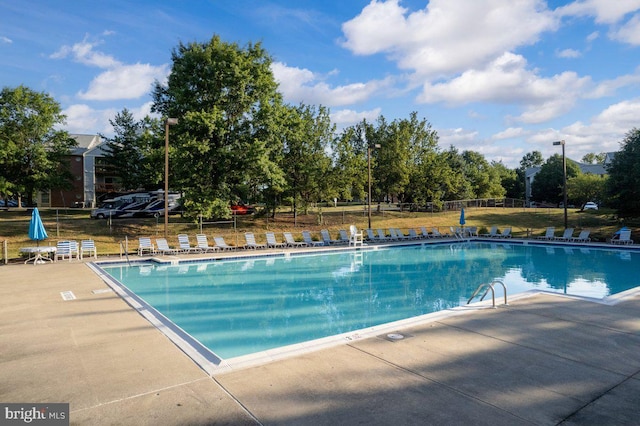 community pool with fence and a patio