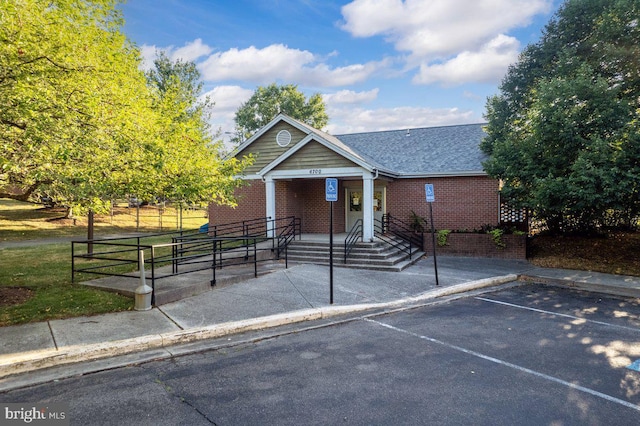 view of front of house featuring uncovered parking and brick siding