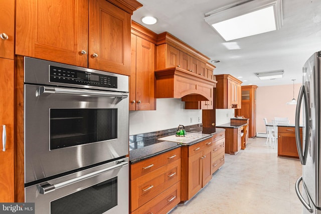 kitchen featuring dark stone countertops, brown cabinets, decorative light fixtures, and appliances with stainless steel finishes