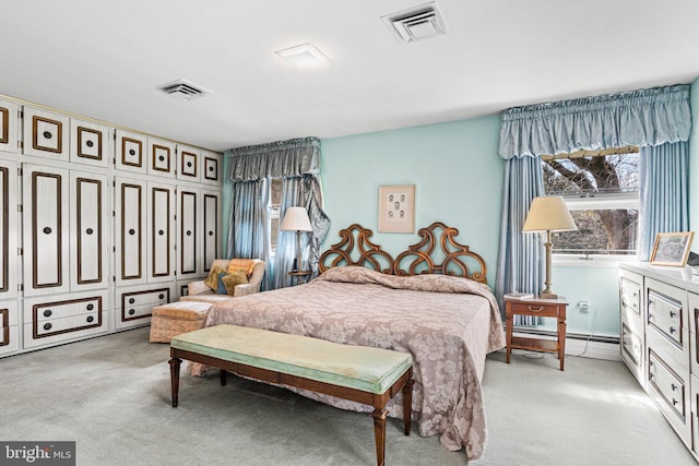 bedroom with visible vents, baseboard heating, and light colored carpet