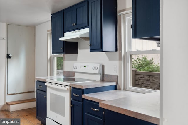 306 W Chapline St, Sharpsburg, MD 21782 - kitchen with blue cabinets, white electric range oven, under cabinet range hood, light countertops, and light wood-style flooring