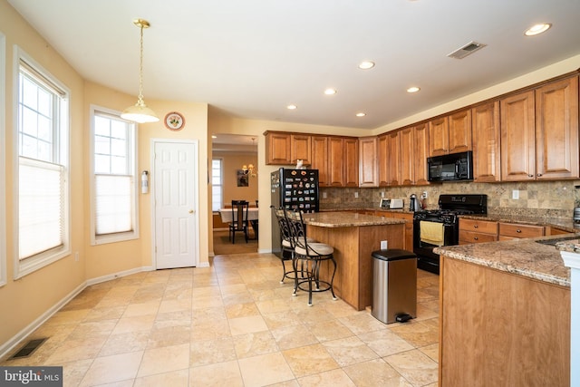 5 Susannah Dr, Chesterfield, NJ 08515 - kitchen with decorative backsplash, visible vents, brown cabinets, black appliances, and a center island