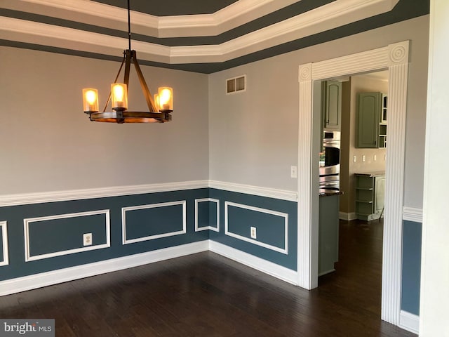 unfurnished dining area featuring an inviting chandelier, dark wood-style floors, crown molding, visible vents, and a tray ceiling