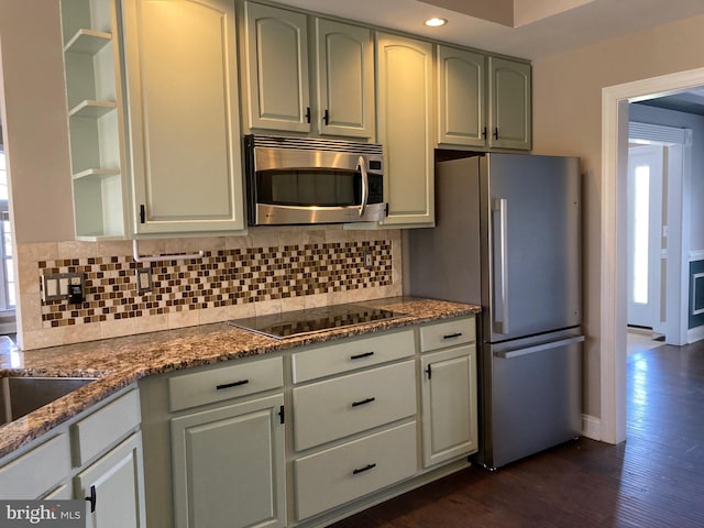kitchen featuring dark stone countertops, dark wood-style flooring, appliances with stainless steel finishes, recessed lighting, and decorative backsplash