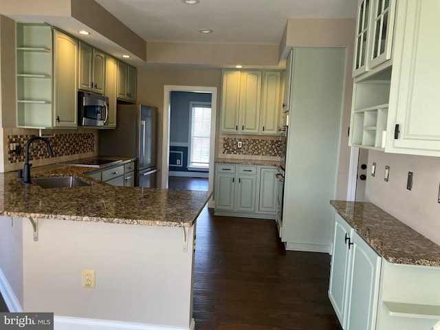 kitchen with a peninsula, open shelves, a sink, stainless steel appliances, and dark wood-style floors