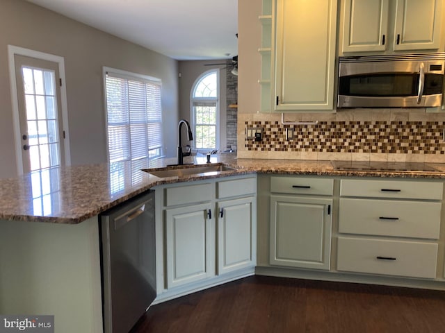 kitchen with ceiling fan, a peninsula, stone countertops, a sink, and stainless steel appliances
