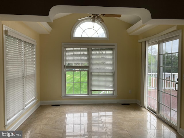 unfurnished dining area featuring a wealth of natural light, ceiling fan, baseboards, and lofted ceiling